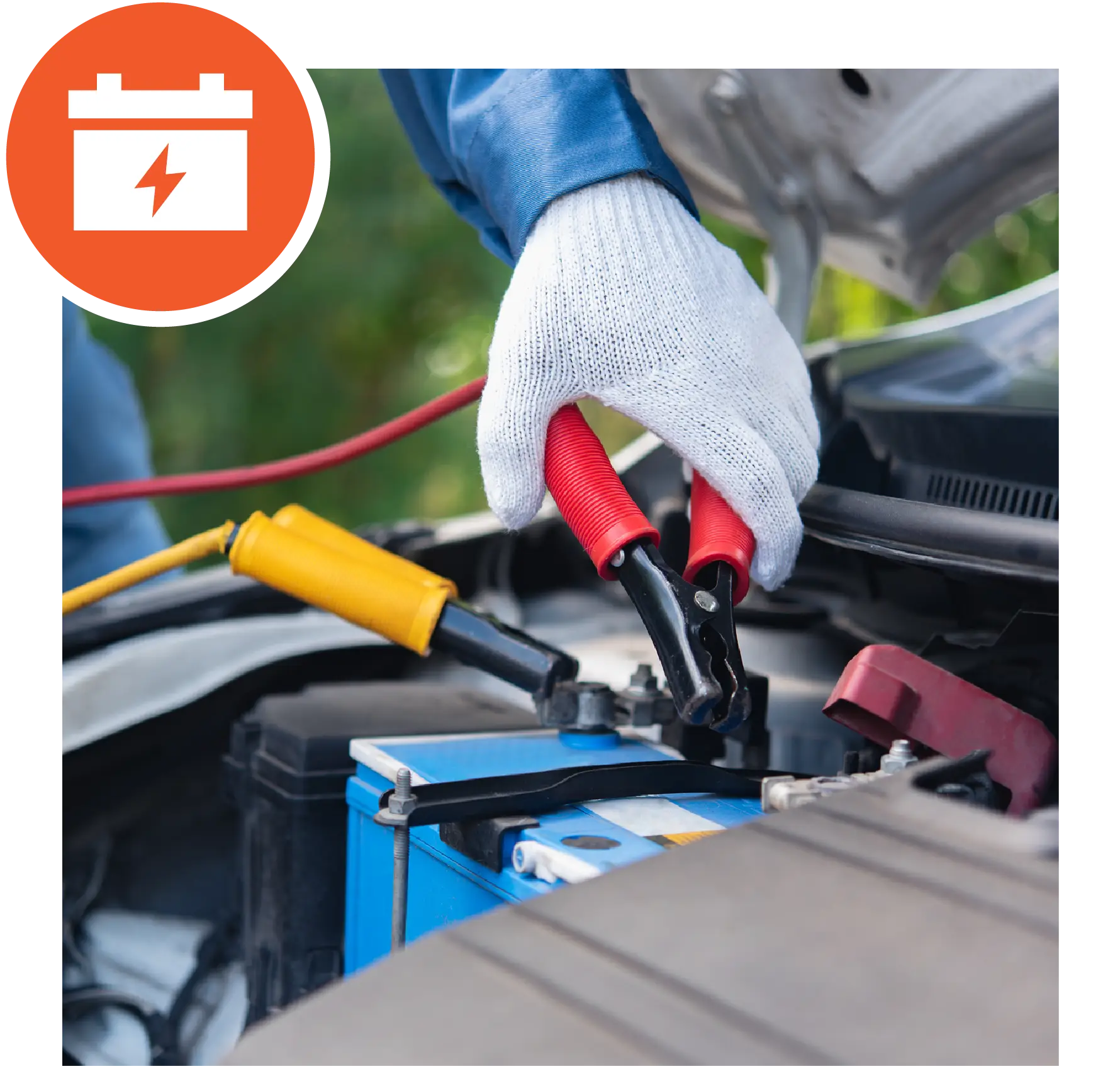 Close-up shot of hand wearing gloves, jump-starting a car with a dead battery.