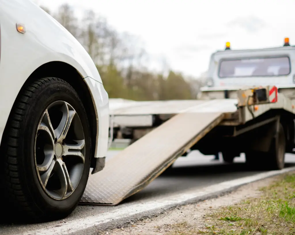 Close up shot of car being towed from side of highway.